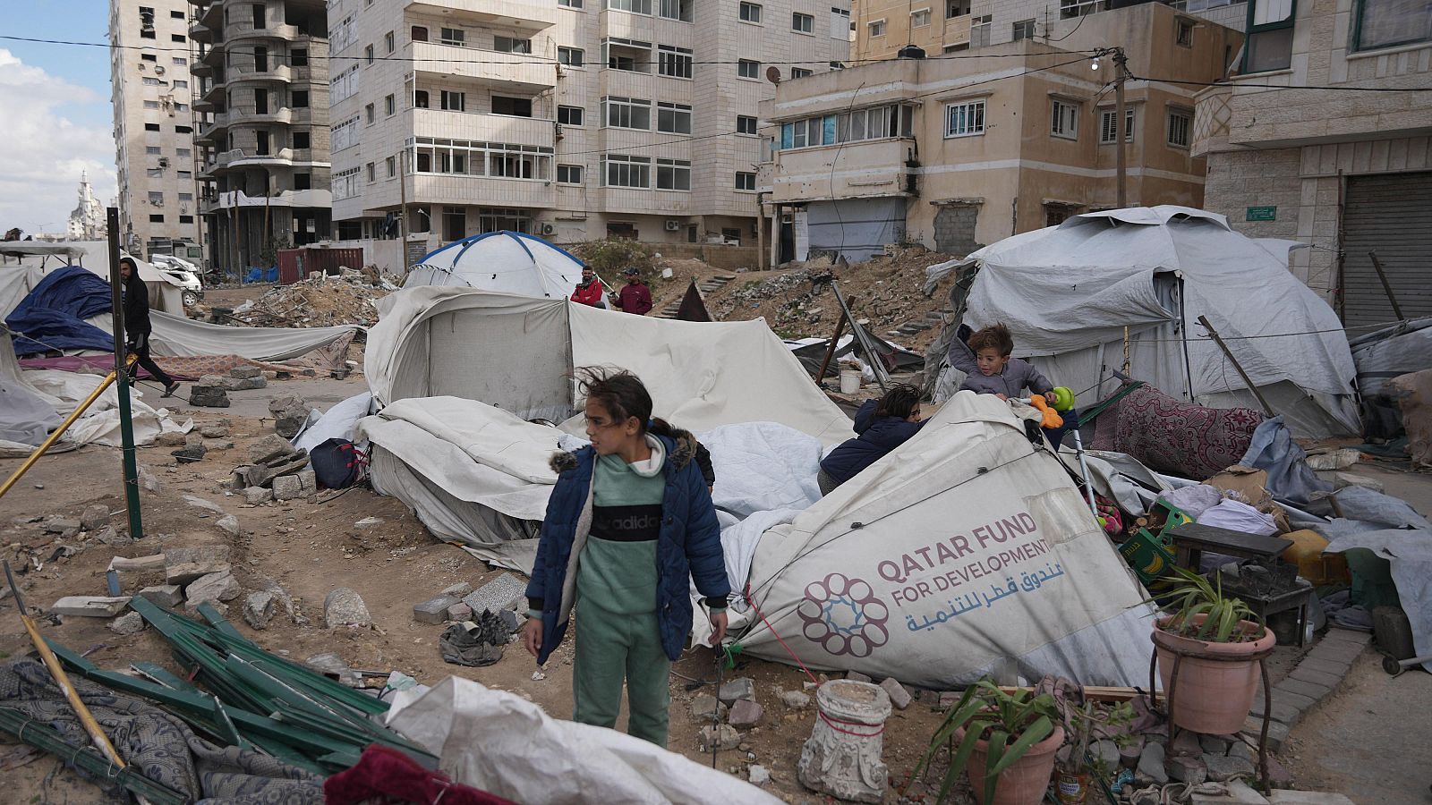 Miembros de una familia junto a su tienda de campaña destruida por fuertes vientos y lluvias en la ciudad de Gaza
