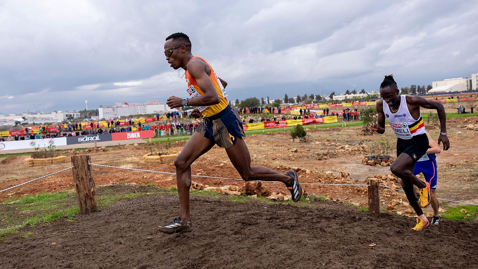 Thierry Ndikumwenayo (c), sobre un tramo embarrado del circuito del Europeo de cross de Antalya 2024