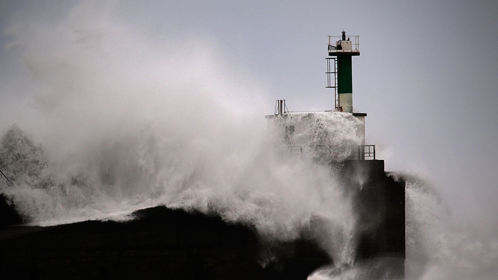 Grandes olas golpean la linterna de faro de San Esteban de Bocamar, Asturias