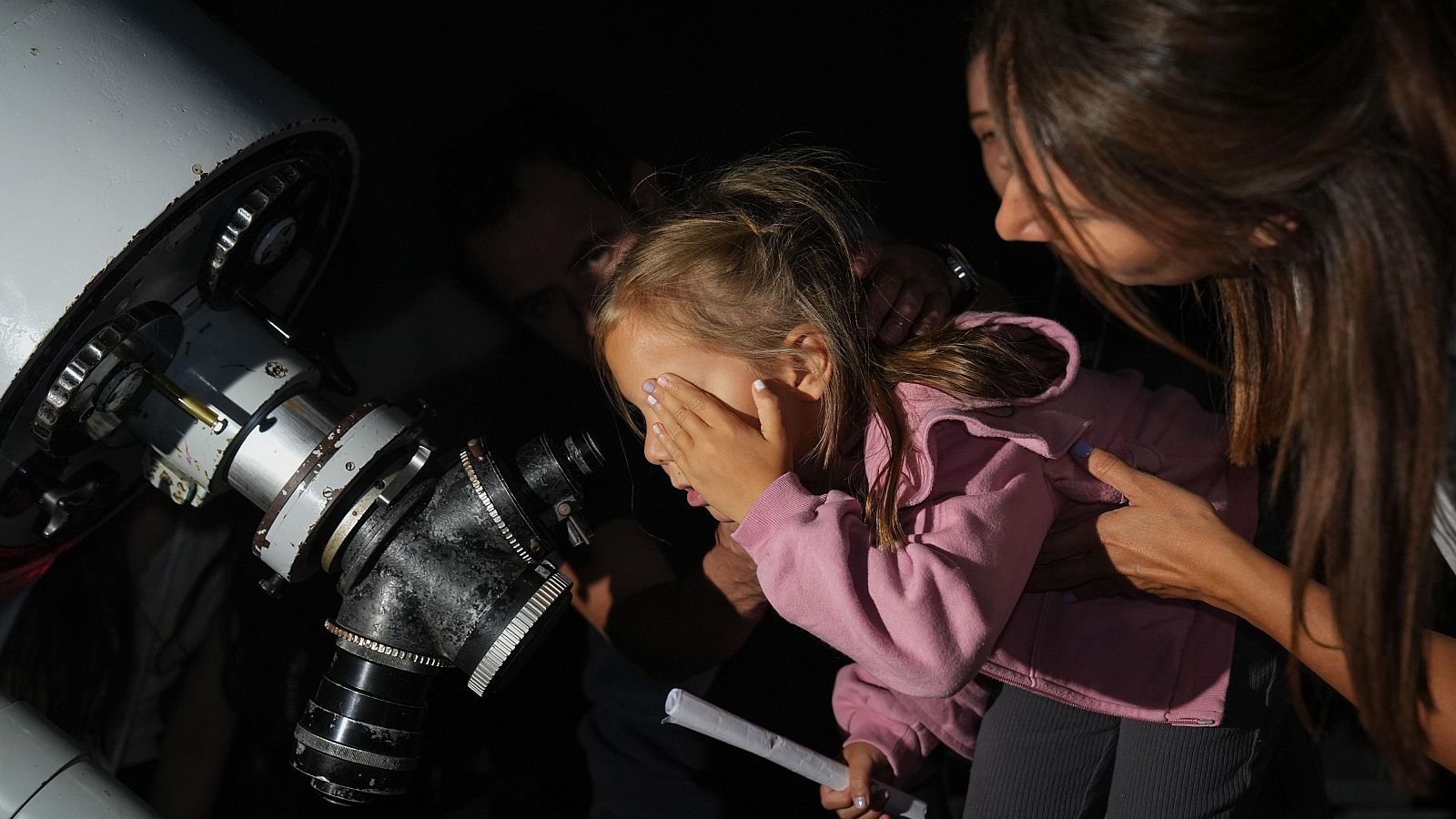 Una niña observa el espacio a través de un telescopio