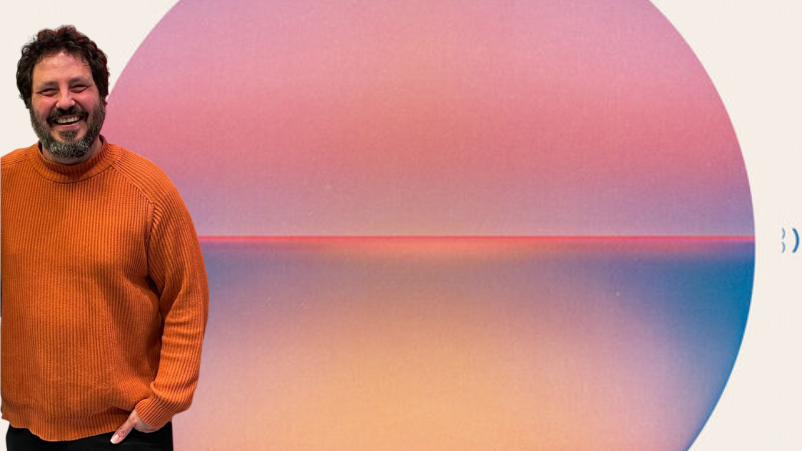 Un hombre sonriente con jersey naranja posa frente a un círculo con degradados de color y una línea roja horizontal, posiblemente para un proyecto audiovisual.