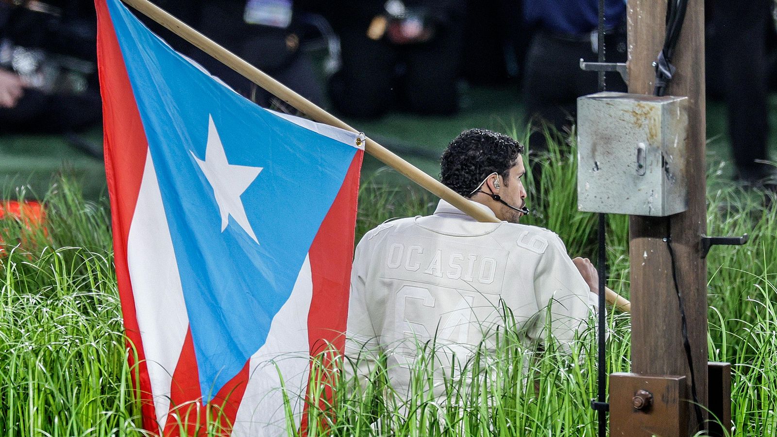 Bad Bunny sostiene la bandera puertorriqueña durante su espectáculo en la Super Bowl.