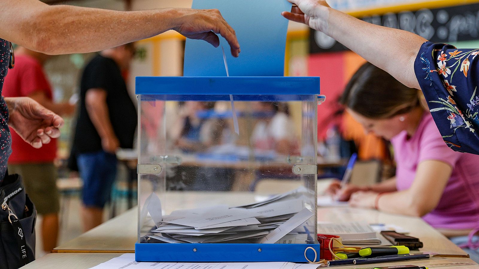 Una mujer deposita su voto en un colegio electoral