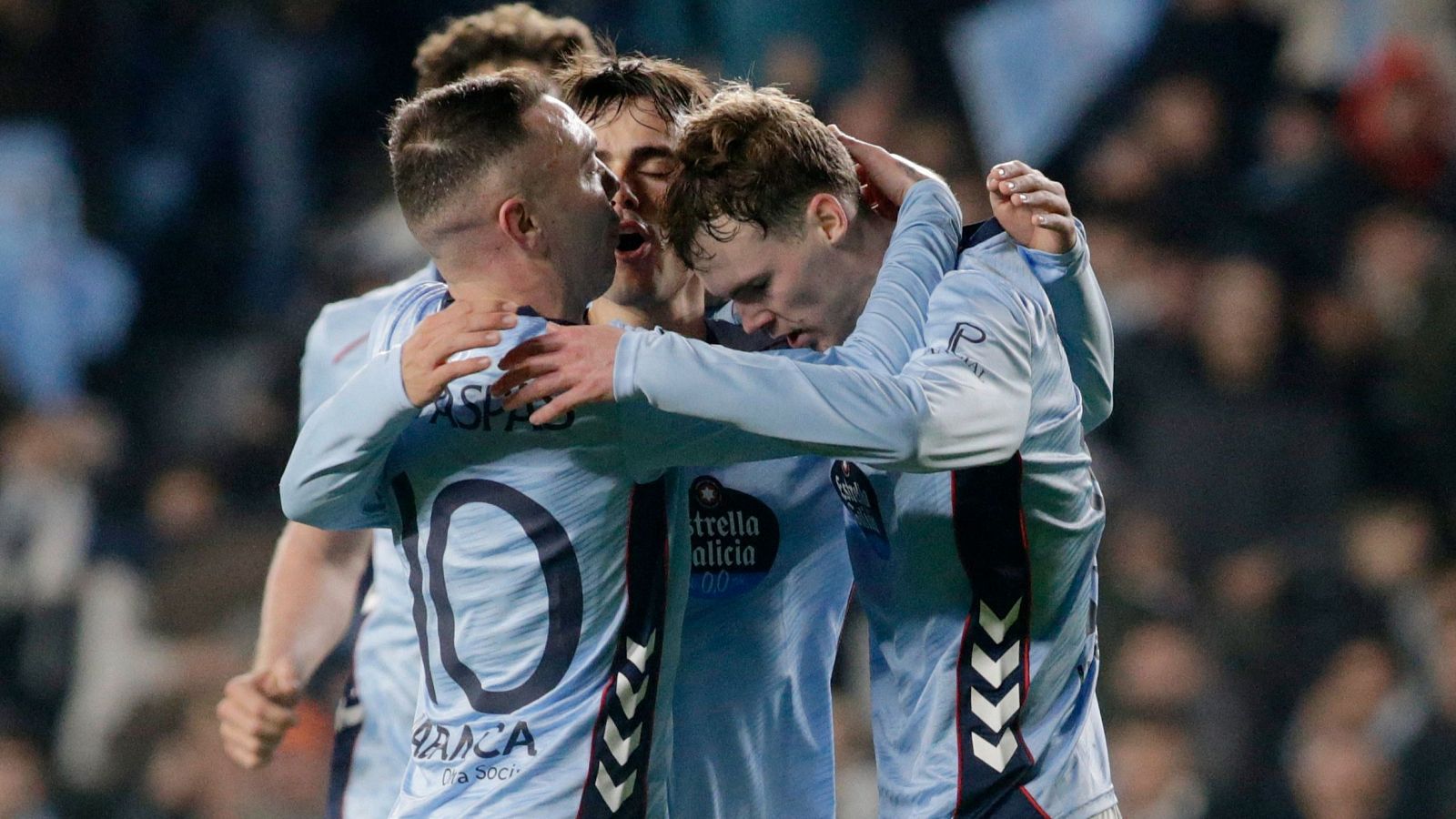 Jugadores del Celta de Vigo celebran un gol en un partido, abrazándose en grupo. Se observa a un jugador con la camiseta número 10 y la equipación celeste del equipo.