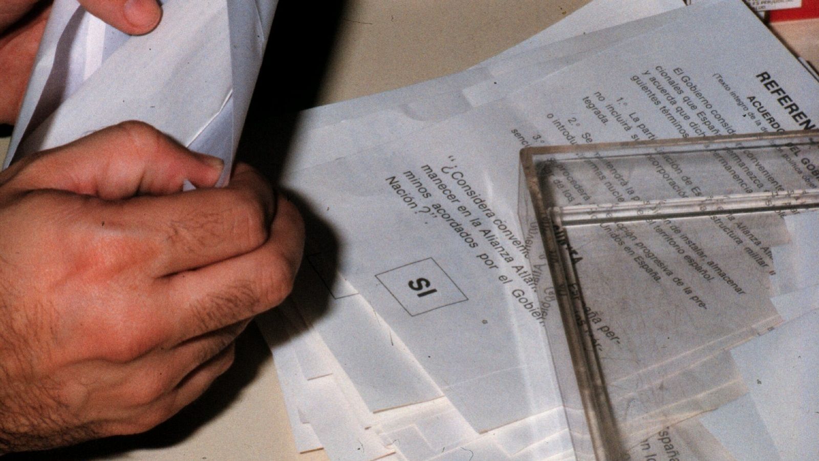 Un hombre hace el recuento el día del referéndum de 1986, con una papeleta de fondo a favor del 'sí'.