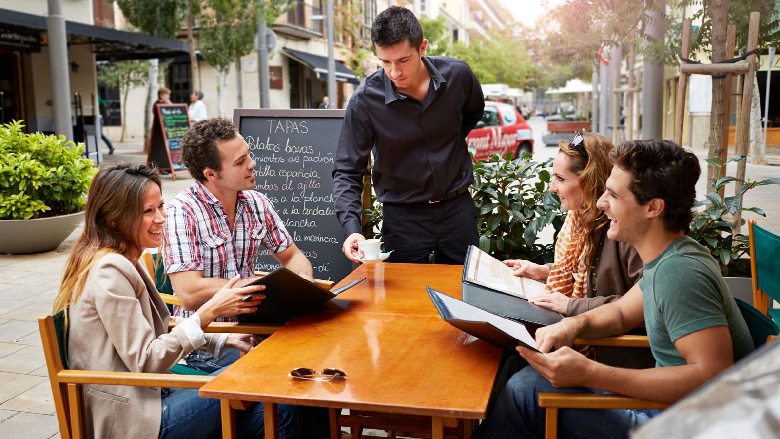 Un camarero atiende una mesa.