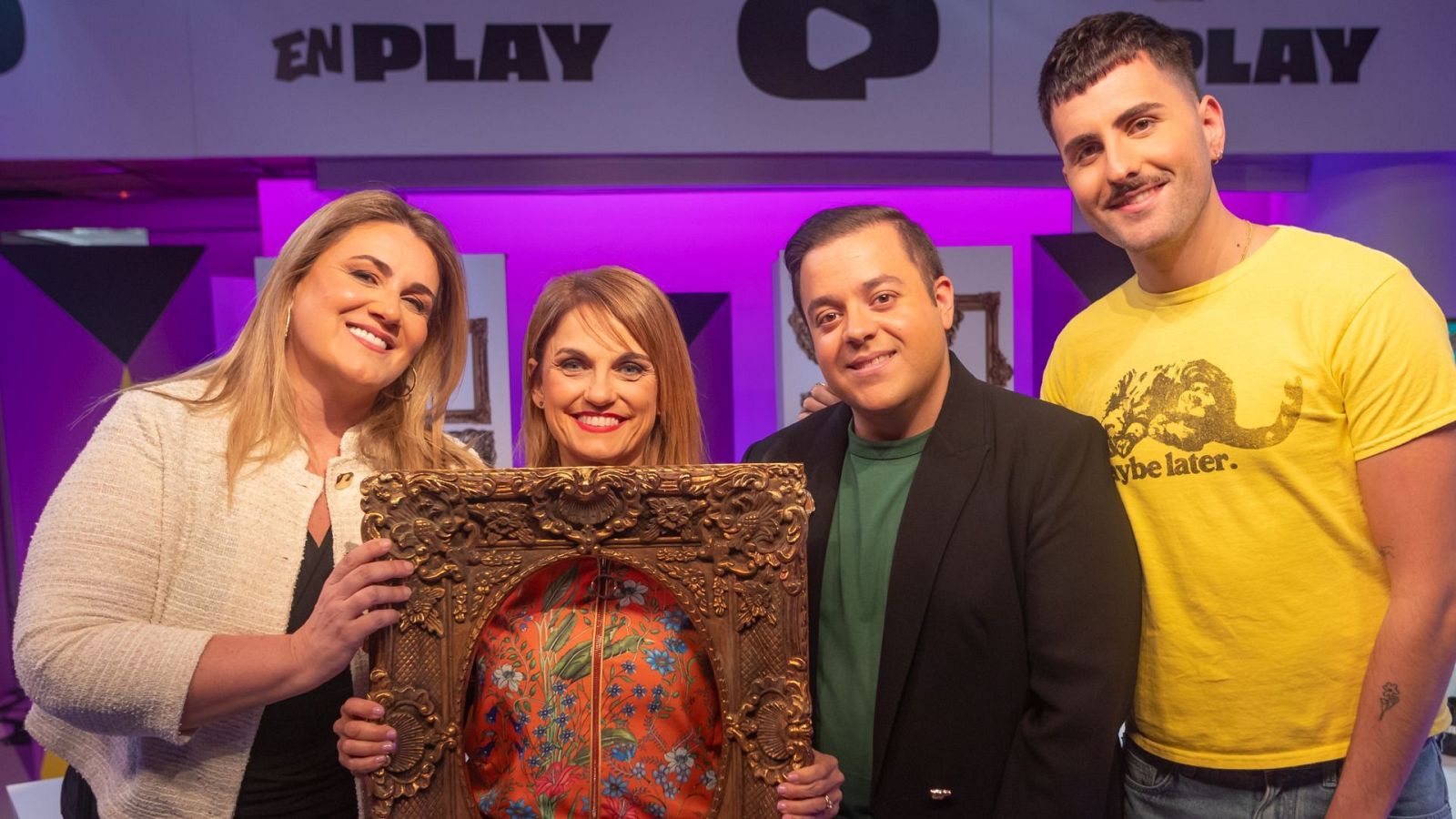 En una imagen, Lourdes Maldonado se encuentra con el equipo de "Menudo Cuadro". Se observa un cuadro con marco dorado y estampado floral, junto a personas vestidas con ropa casual, en un fondo morado.