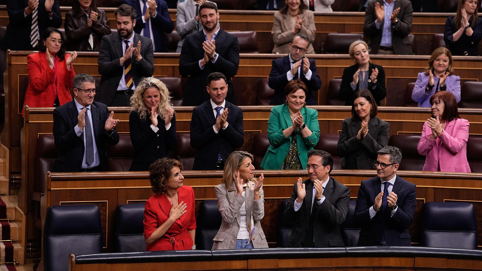 La vicepresidenta primera, María Jesús Montero (i), recibe el aplauso de su bancada durante la sesión de control al Gobierno