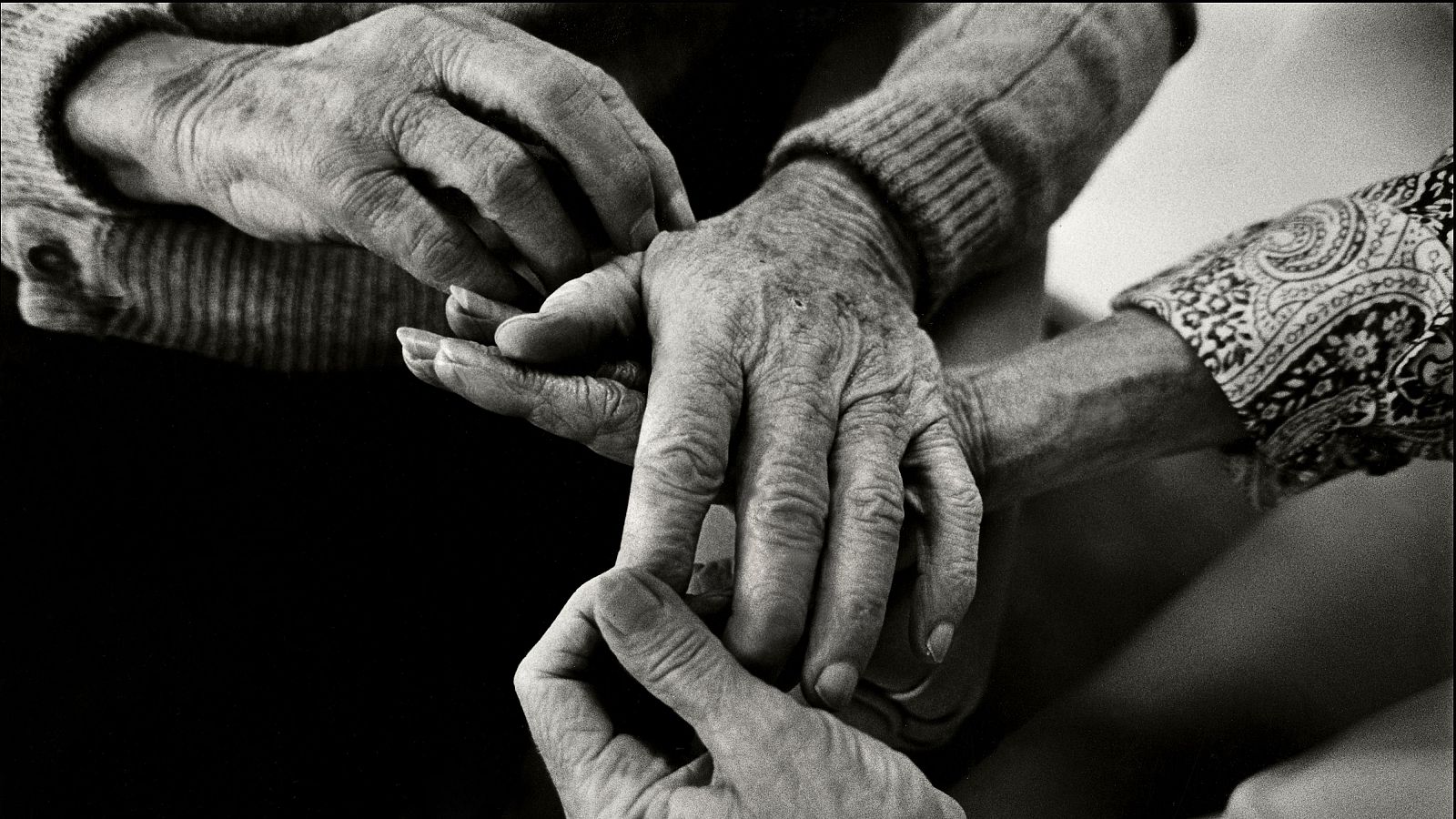 Imagen de las manos de dos personas mayores entrelazándose