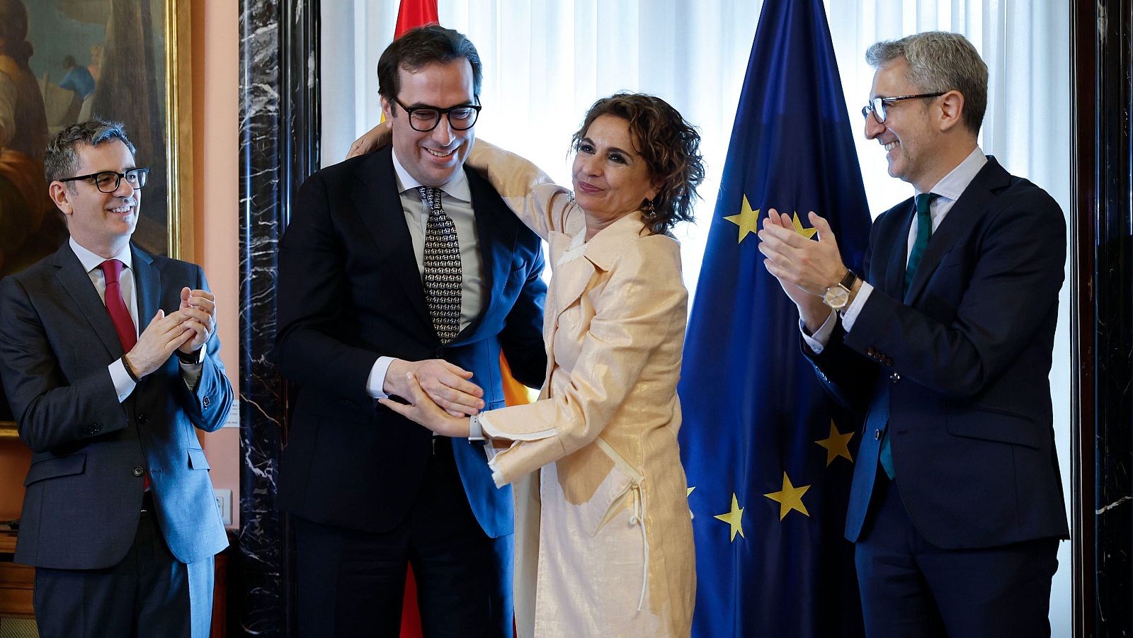 La exvicepresidenta primera del Gobierno, María Jesus Montero abraza al nuevo vicepresidente primero del Gobierno y ministro de Economía, Carlos Cuerpo, junto al nuevo ministro de Hacienda, Arcadi España.