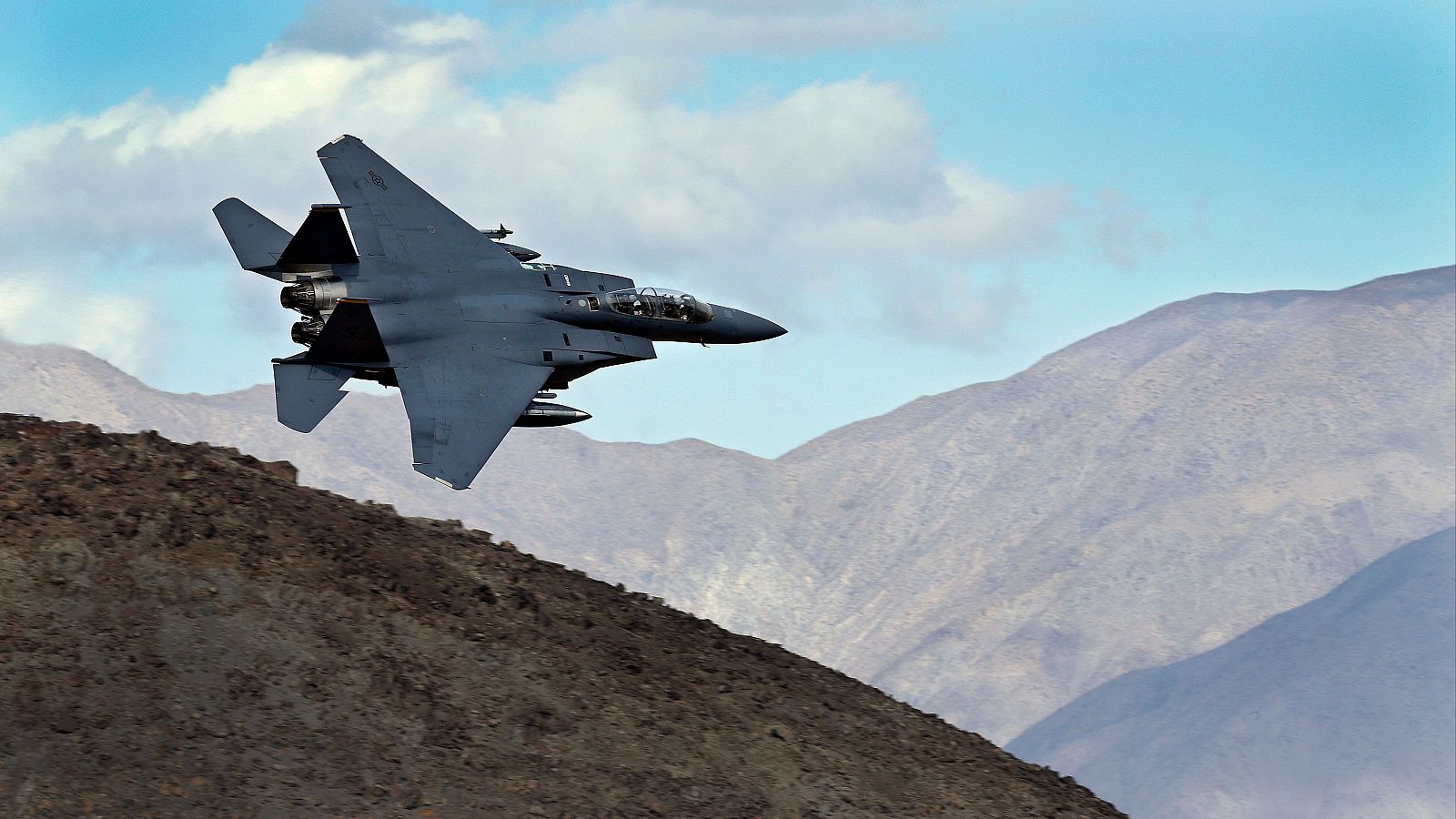 Un F-15E Strike Eagle de la Fuerza Aérea estadounidense se muestra en vuelo, destacando su diseño y capacidad en un cielo despejado.