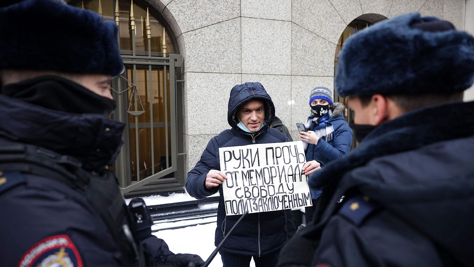 Fotografía de un hombre que sostiene una pancarta con el letrero "Manos fuera de Memorial. Libertad para los presos políticos" se manifiesta frente al Tribunal Supremo de Rusia