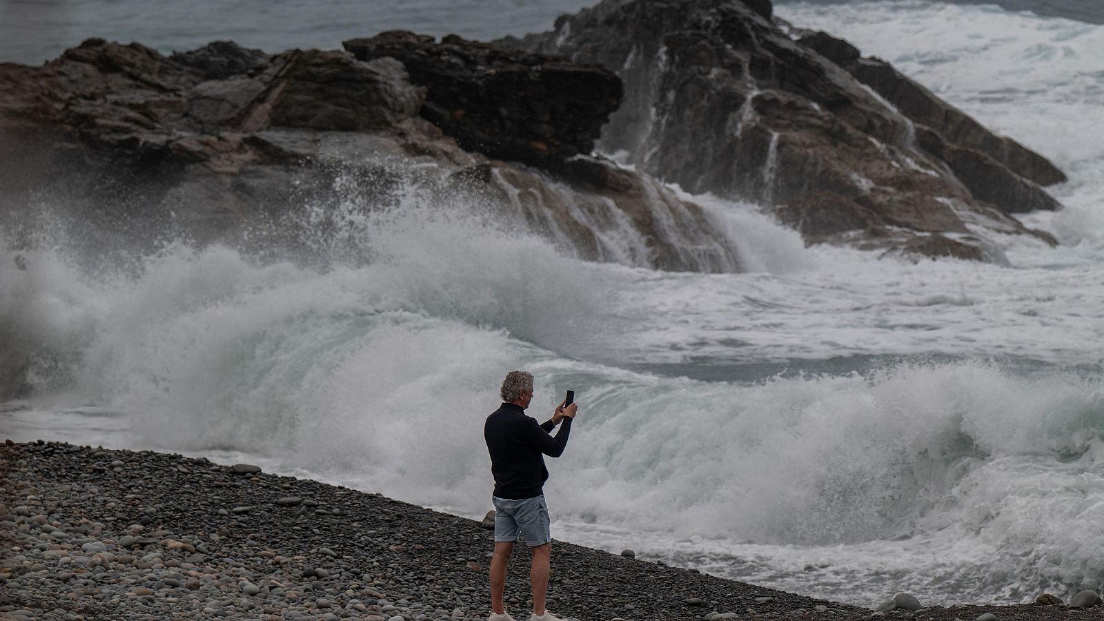 Una persona se protege de la lluvia en Málaga