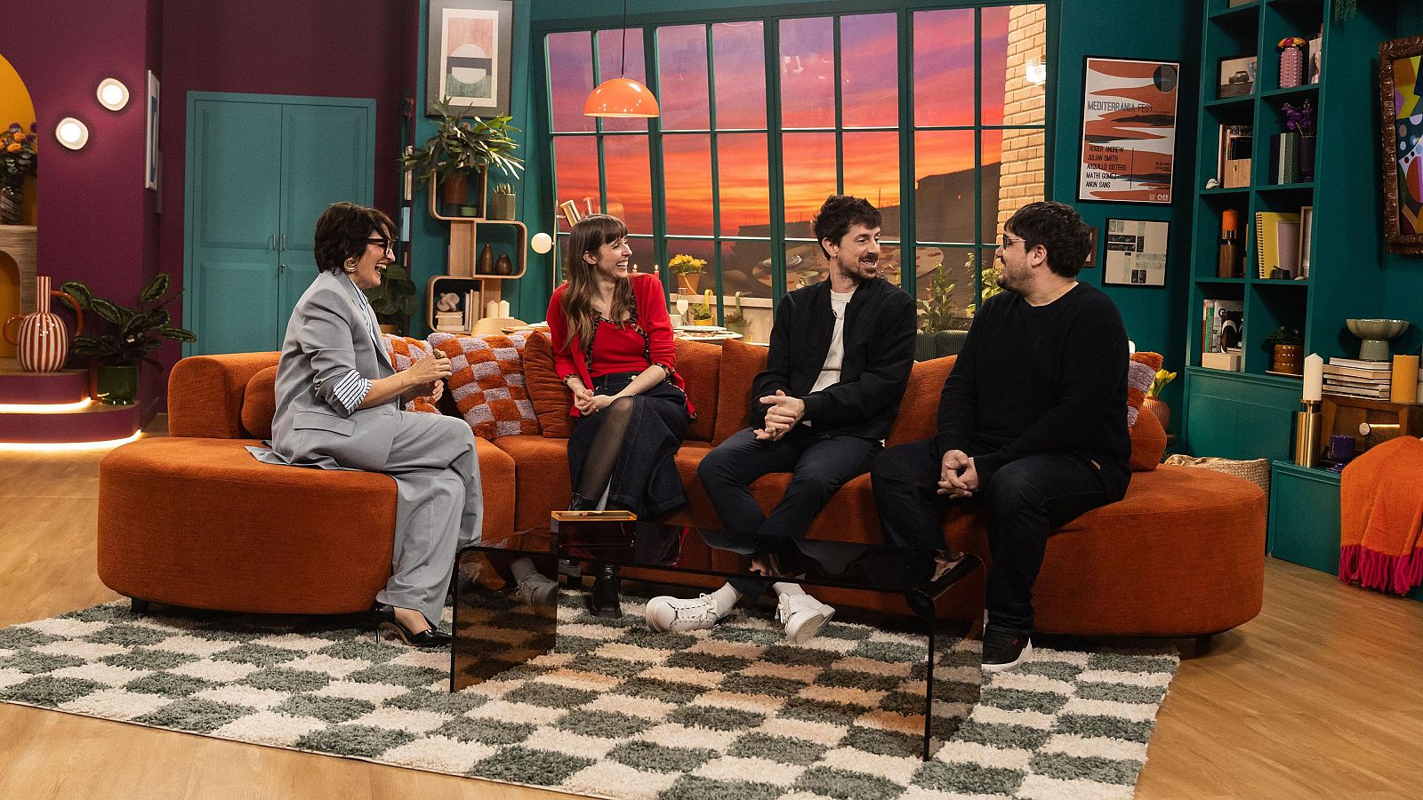 Sílvia Abril, Paula Malia, Ignasi Taltavull i Tomàs Fuentes comparteixen espai en un plató de televisió. A la imatge, es pot veure un sofà, una taula de vidre i una finestra amb vistes a un capvespre.