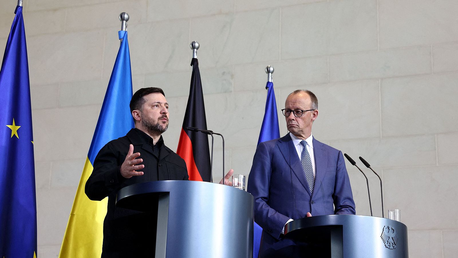 Fotografía del canciller alemán Friedrich Merz con un traje azul y del presidente ucraniano Volódimir Zelensky con un abrigo negro, asisten a una conferencia de prensa el día de las consultas gubernamentales germano-ucranianas
