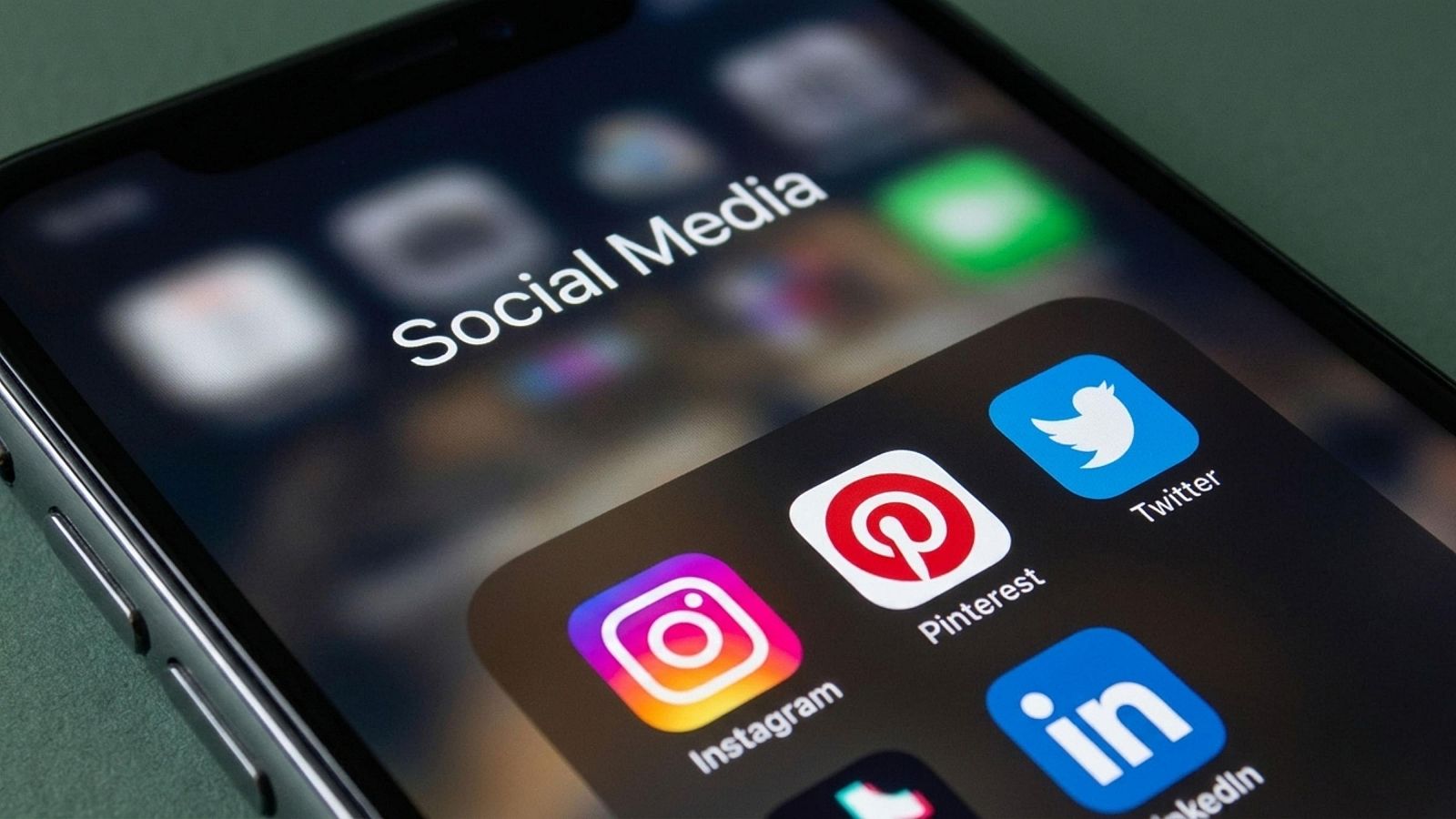 En la pantalla de un teléfono móvil se observa el título "Social Media" y los iconos de varias aplicaciones, como Instagram, Pinterest, Twitter y LinkedIn.