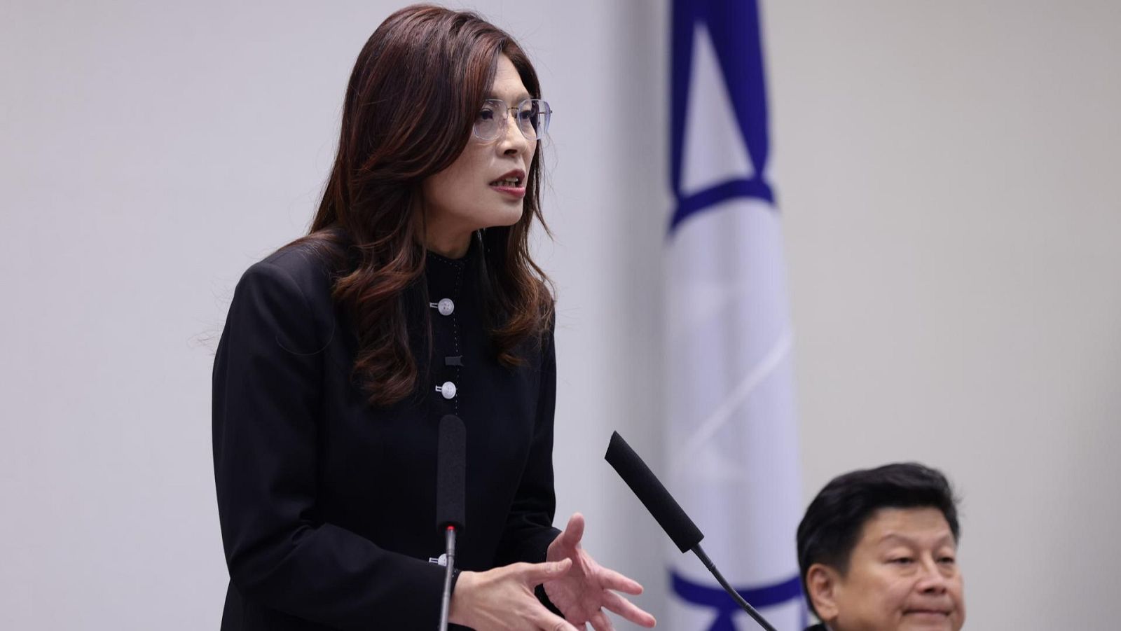 Fotografía de la presidenta del principal partido de oposición de Taiwán, el Kuomintang (KMT), Cheng Li-wun (izquierda), vestida con un traje negro hablando dentro de la sede del partido en Taipéi, Taiwán