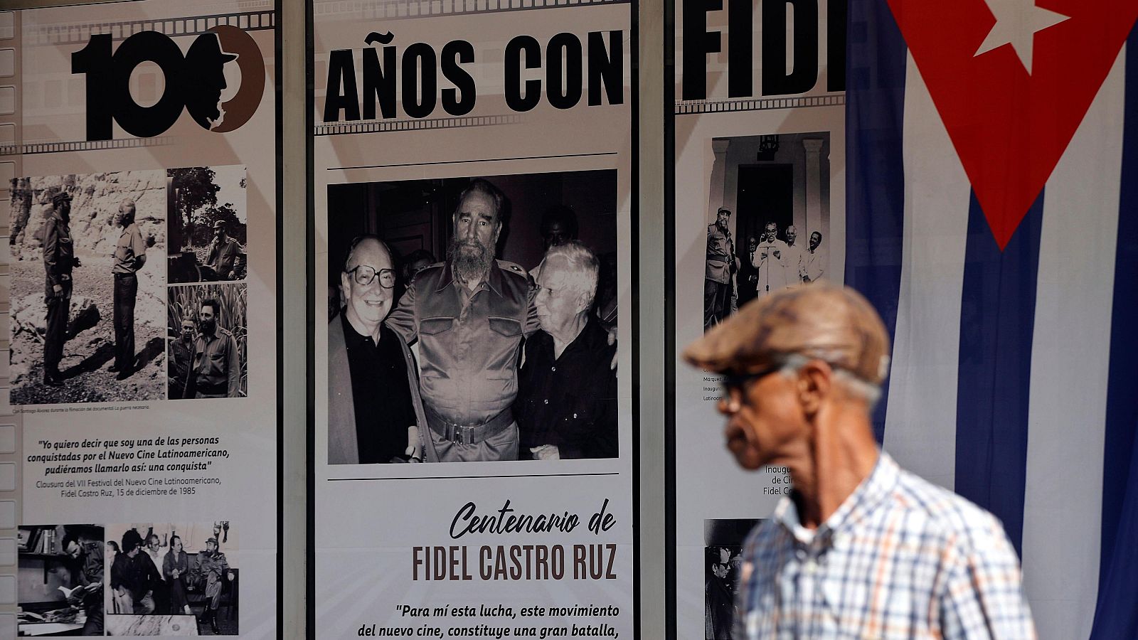 Una persona camina frente a un mural con fotografías del fallecido líder cubano Fidel Castro en La Habana