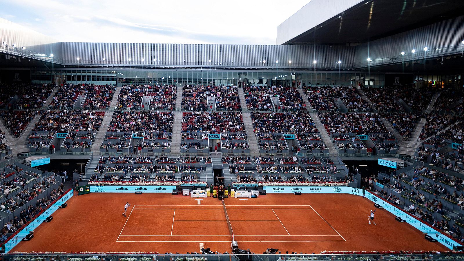 Vista panorámica de la final del Mutua Madrid Open 2025 en la Caja Mágica, con Casper Ruud y Jack Draper en la cancha de tierra batida y miles de espectadores en las gradas.