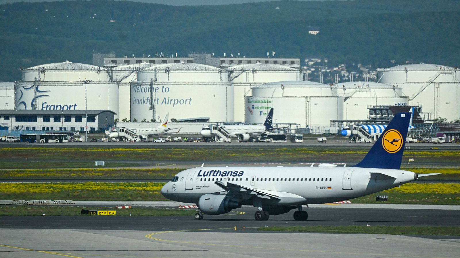 Fotografía de un avión de Lufthansa que se desplaza por la pista cerca de tanques de queroseno el día de la ceremonia oficial de inauguración de la Terminal 3 del aeropuerto de Frankfurt, en Frankfurt, Alemania