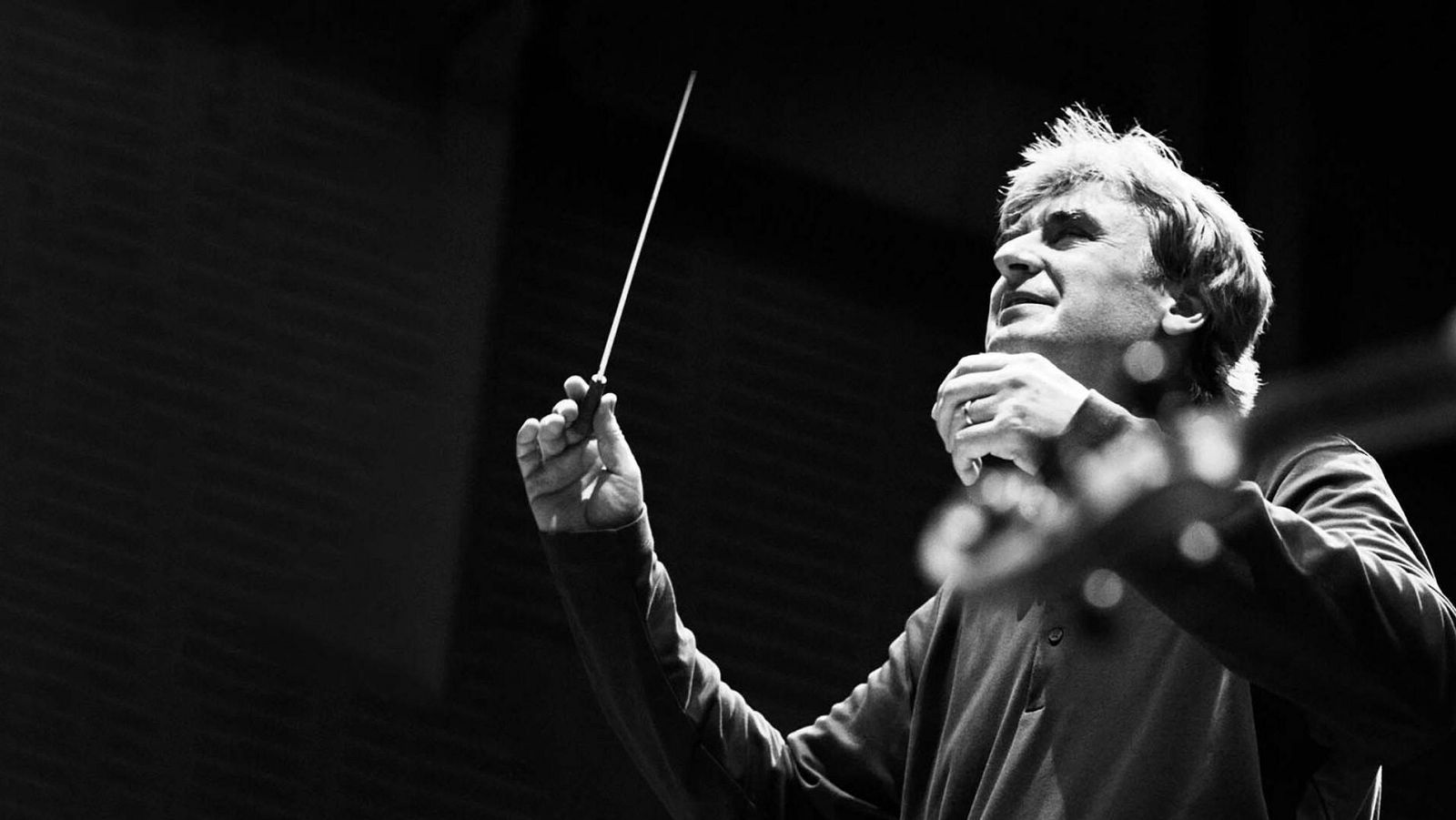 Thomas Dausgaard, director de orquesta, en un primer plano en blanco y negro, dirigiendo con pasión y concentración, sosteniendo una batuta.