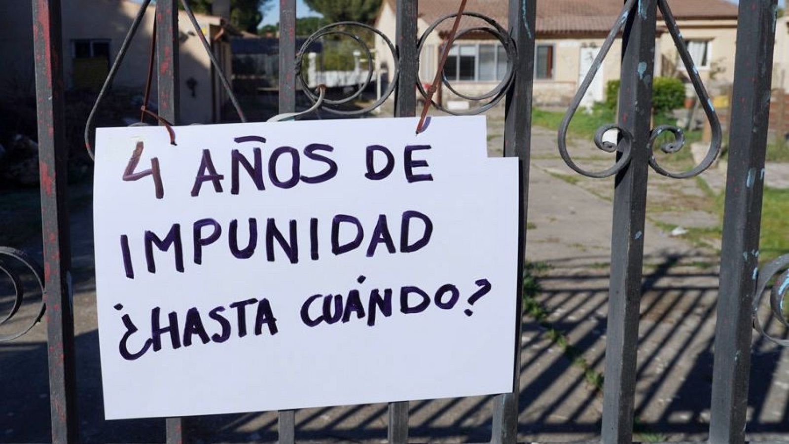 Fotografía de la Verja de la puerta del chalé que perteneció al único investigado por el caso de Esther López con un cartel en el que puede leerse "4 años de impunidad ¿hasta cuándo? durante la investigación del sótano hallado a principios de abril