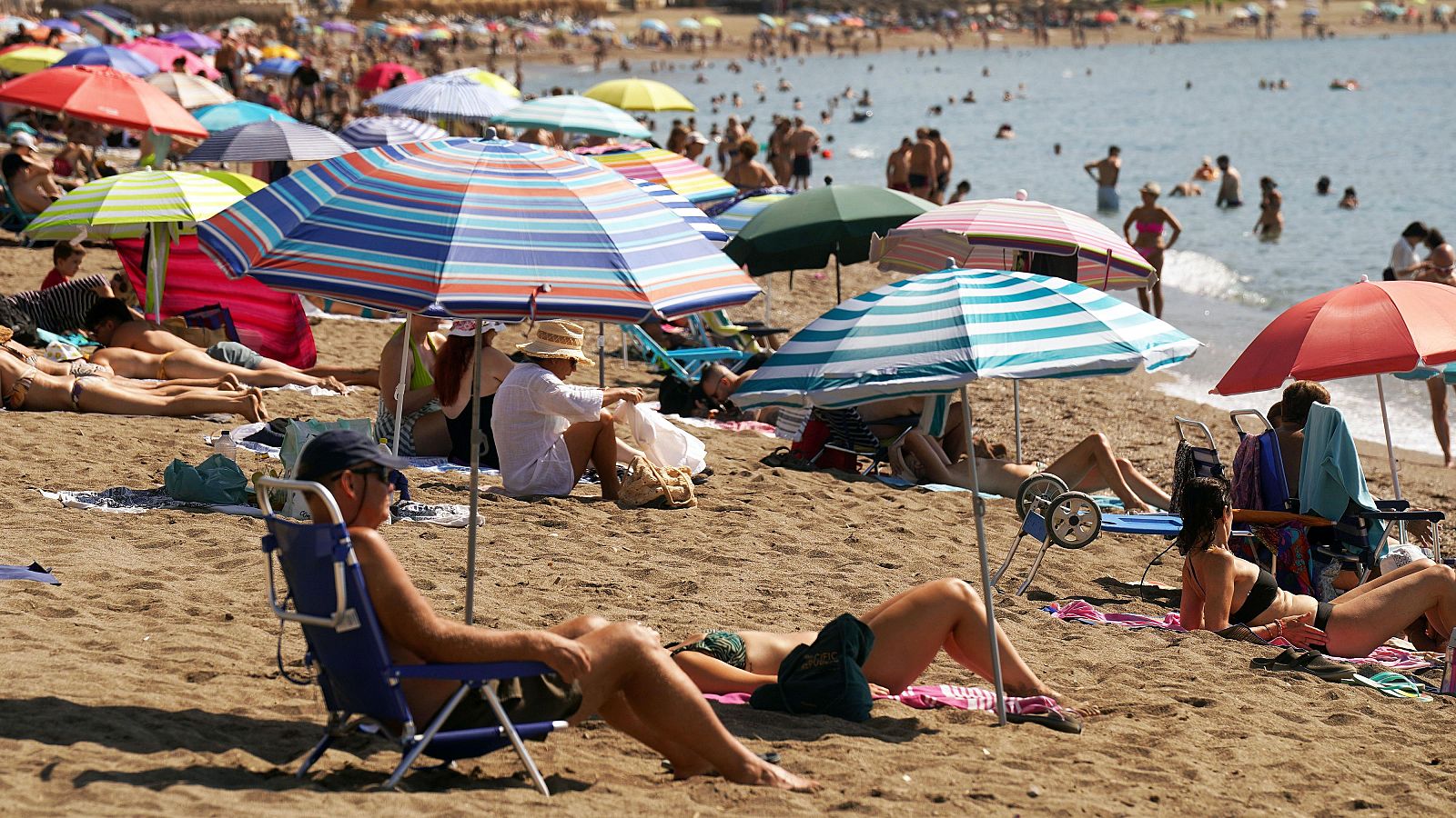 Turistas y malagueños toman el sol en la Malagueta