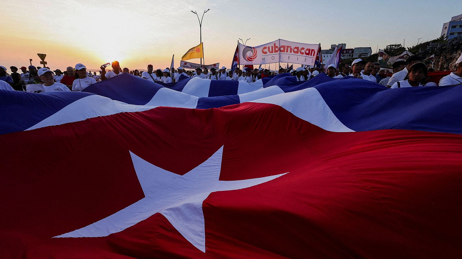 Manifestantes sostienen una enorme bandera nacional cubana durante un desfile por el Día del Trabajo en La Habana, Cuba.