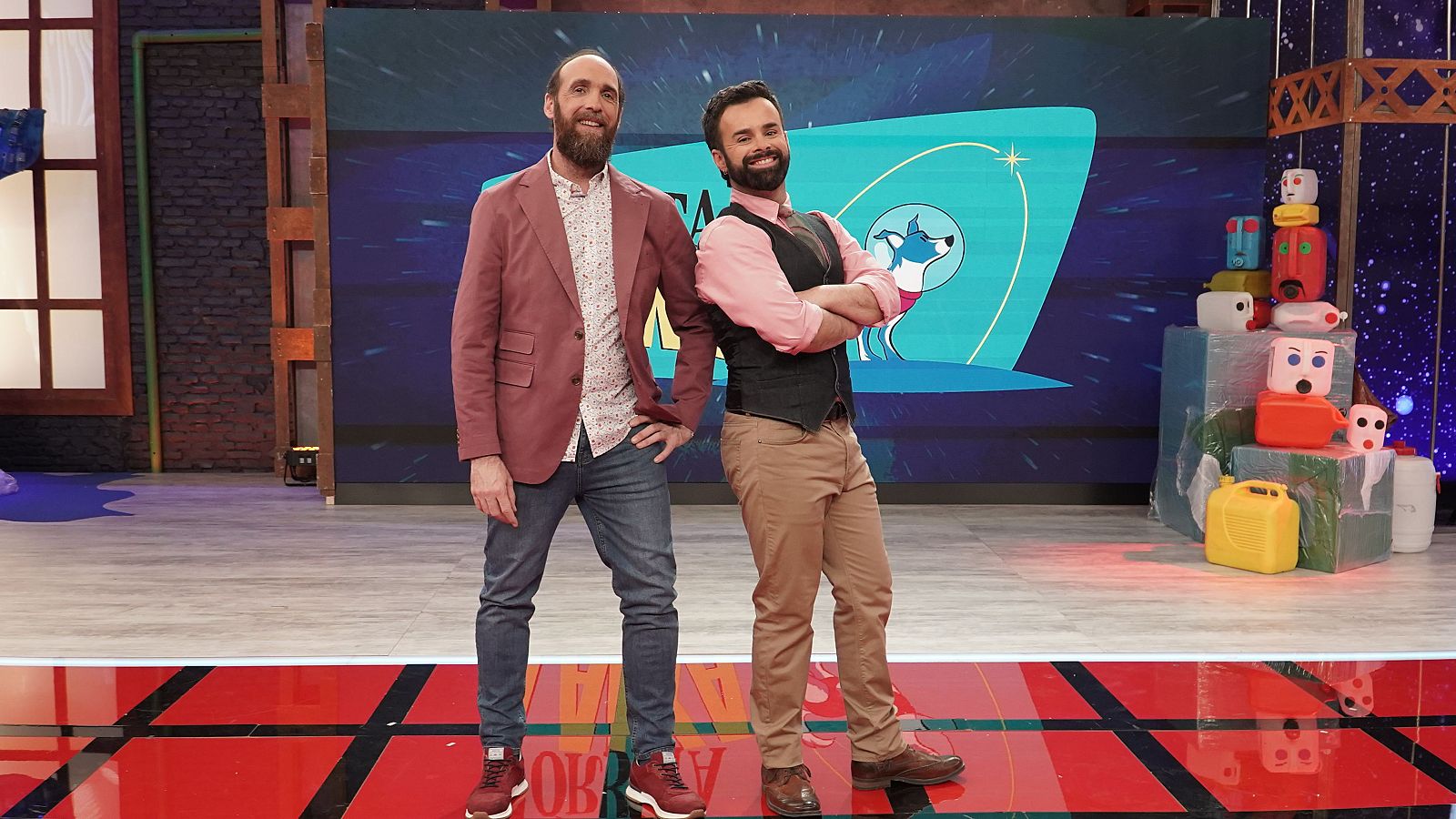 Eduardo Sáenz de Cabezón y Ricardo Moure posan sonrientes en el plató de "Órbita Laika", con un fondo espacial y el título del programa visible.