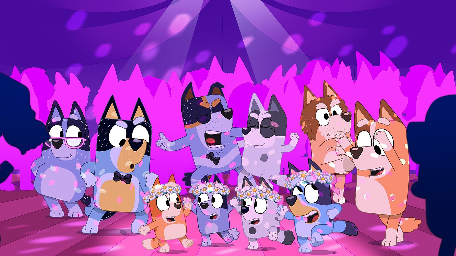 Diez personajes caninos de "Bluey" bailan en una fiesta con luces de discoteca moradas y rosas. Cachorros con coronas de flores y adultos con expresiones alegres llenan la escena festiva.