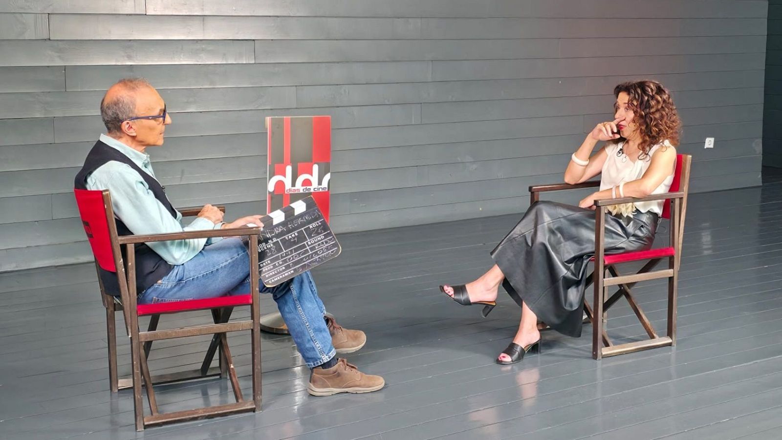 Gerardo Sánchez, director de 'Días de cine', y la productora Sandra Hermida en una entrevista. Sánchez sostiene una claqueta con el logo del programa.