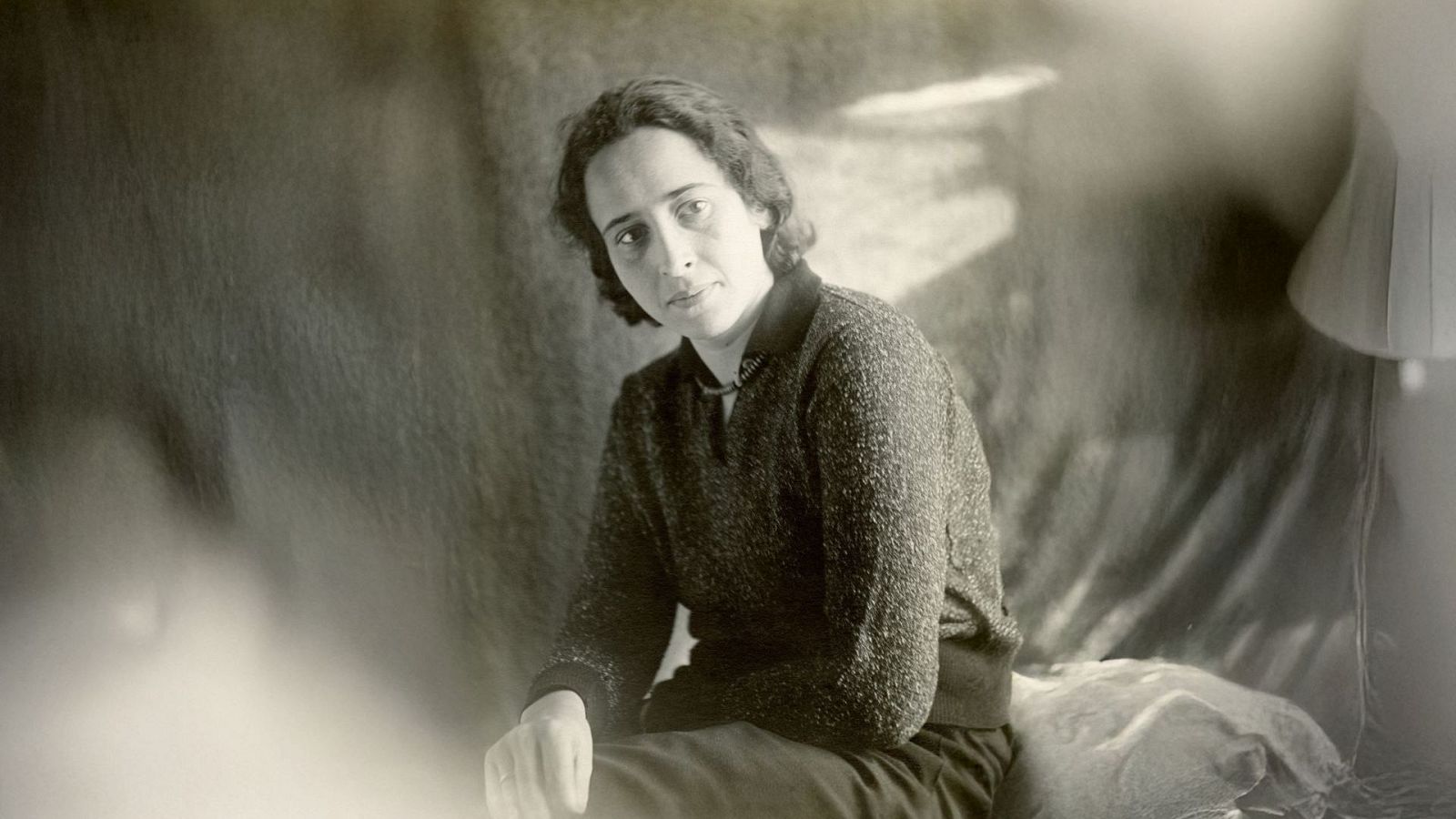 Hannah Arendt, 1930. Retrato en blanco y negro de la filósofa sentada, con expresión seria y jersey de punto.