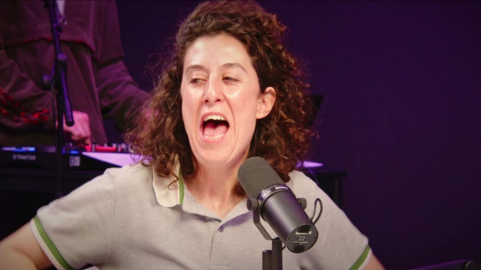 Laura del Val, con expresión enérgica, en un estudio de grabación de podcast o radio, con micrófono profesional y equipo "TRAKTOR" al fondo.