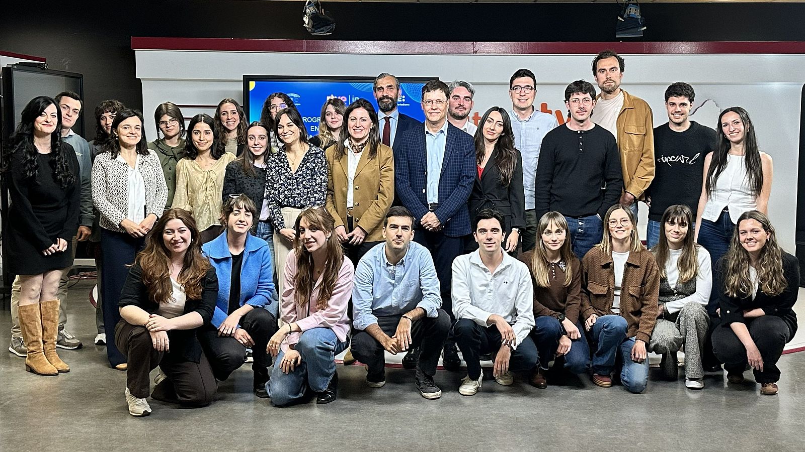 Grupo de 29 personas posando en interior. Se identifica a José Manuel Pérez Tornero. Fondo con logotipos de RTVE y UIMP.