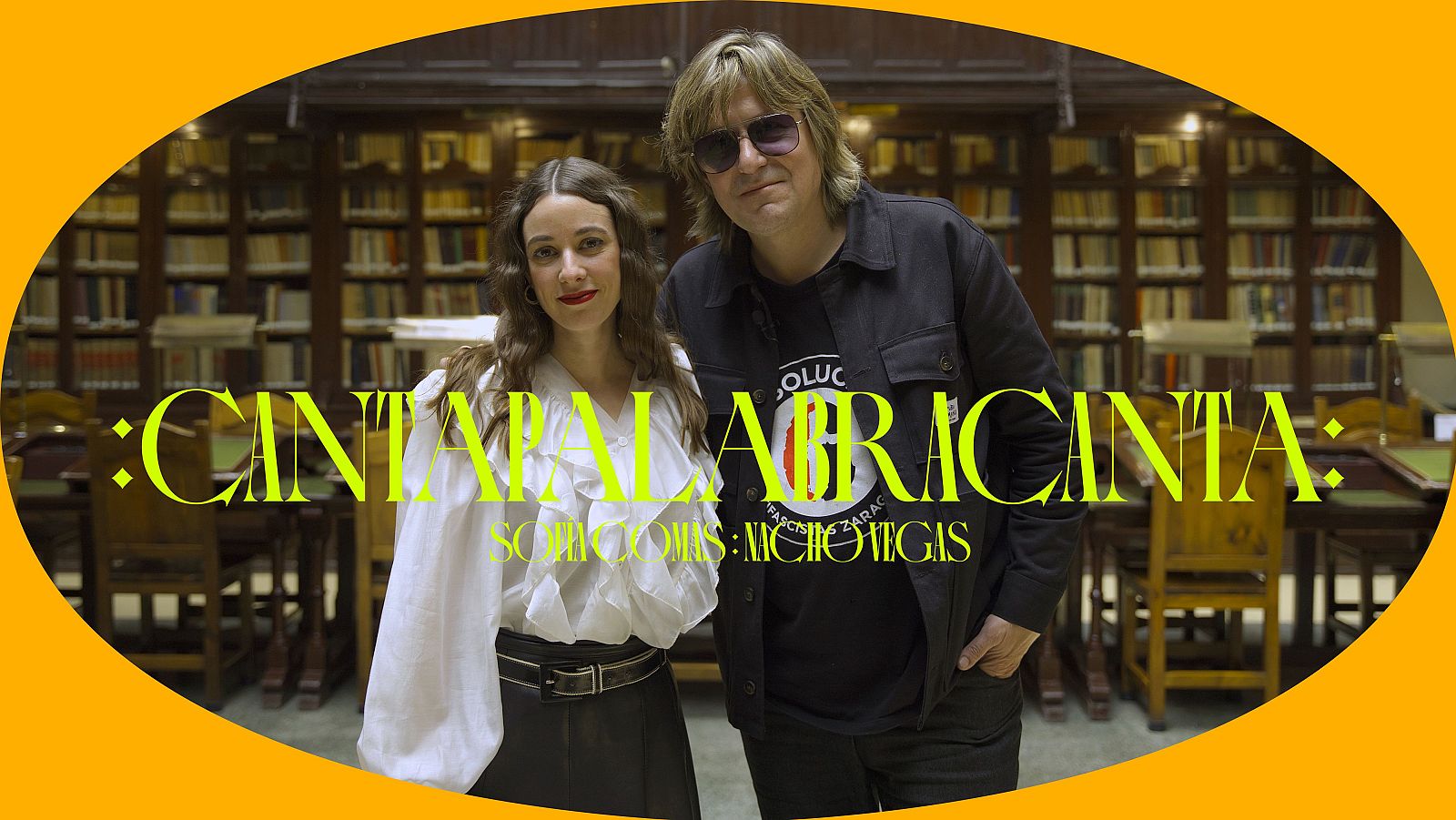 María Rodés y Diego Vasallo posan sonrientes en una biblioteca, con el texto promocional ":CANTAPALABRACANTA: SCRIPTORES: MICHOTIGAS" superpuesto.