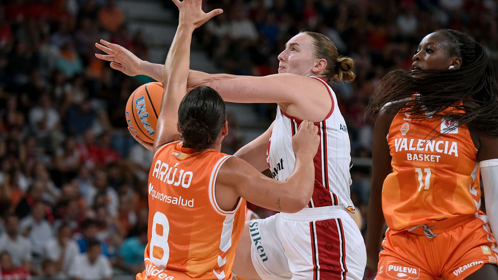 Jugadoras del Valencia Basket y Casademont Zaragoza compiten en un partido de la Liga Femenina Endesa. Se observa a Araujo (Valencia, 8) con el balón, defendida por una jugadora del Zaragoza.