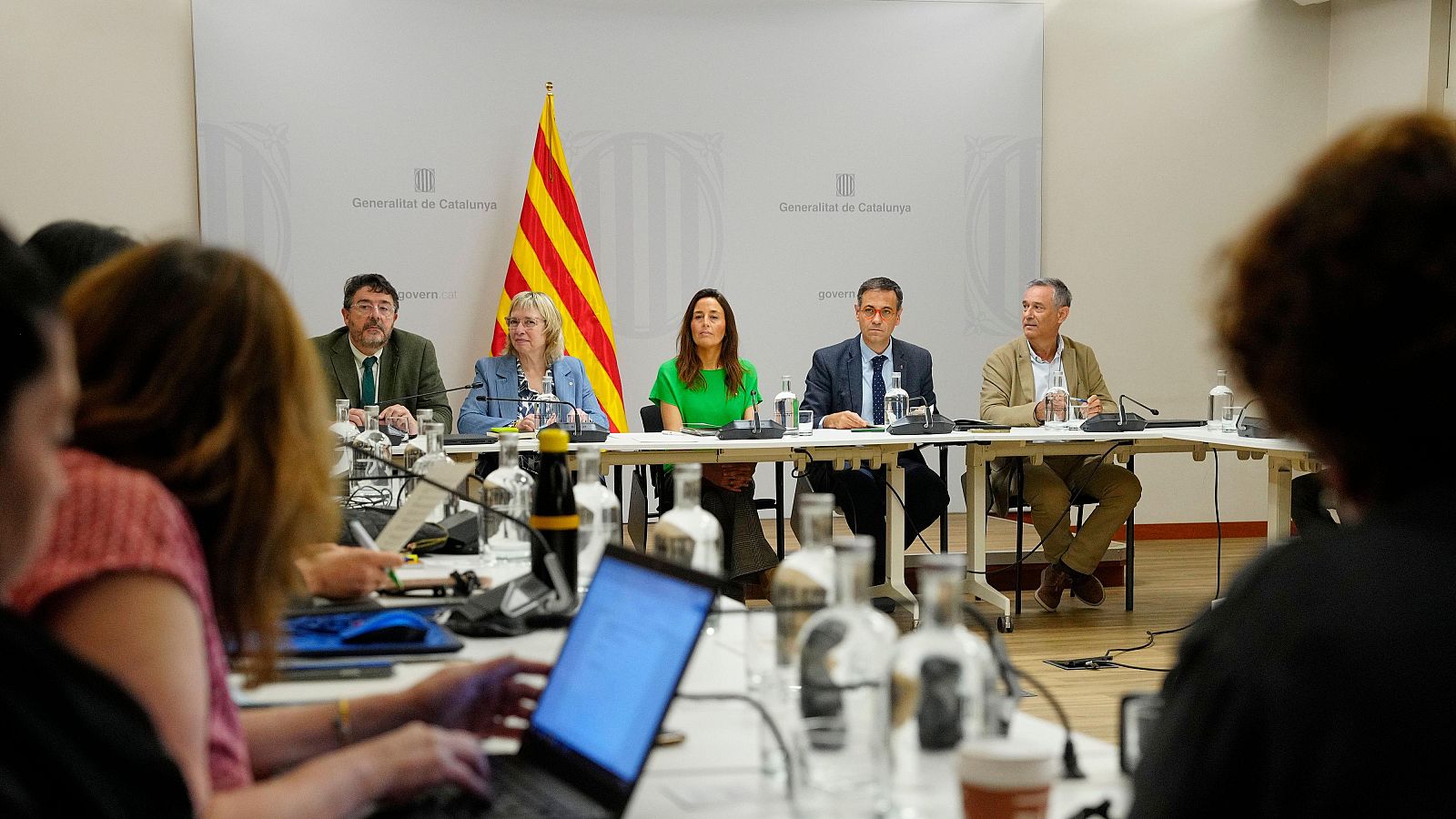 Reunió de la Mesa Sectorial d'Educació amb Anna Simó i Niubó a la Generalitat de Catalunya. Cinc persones a la taula amb micròfons i documents. Al fons, logo de la Generalitat i senyera.