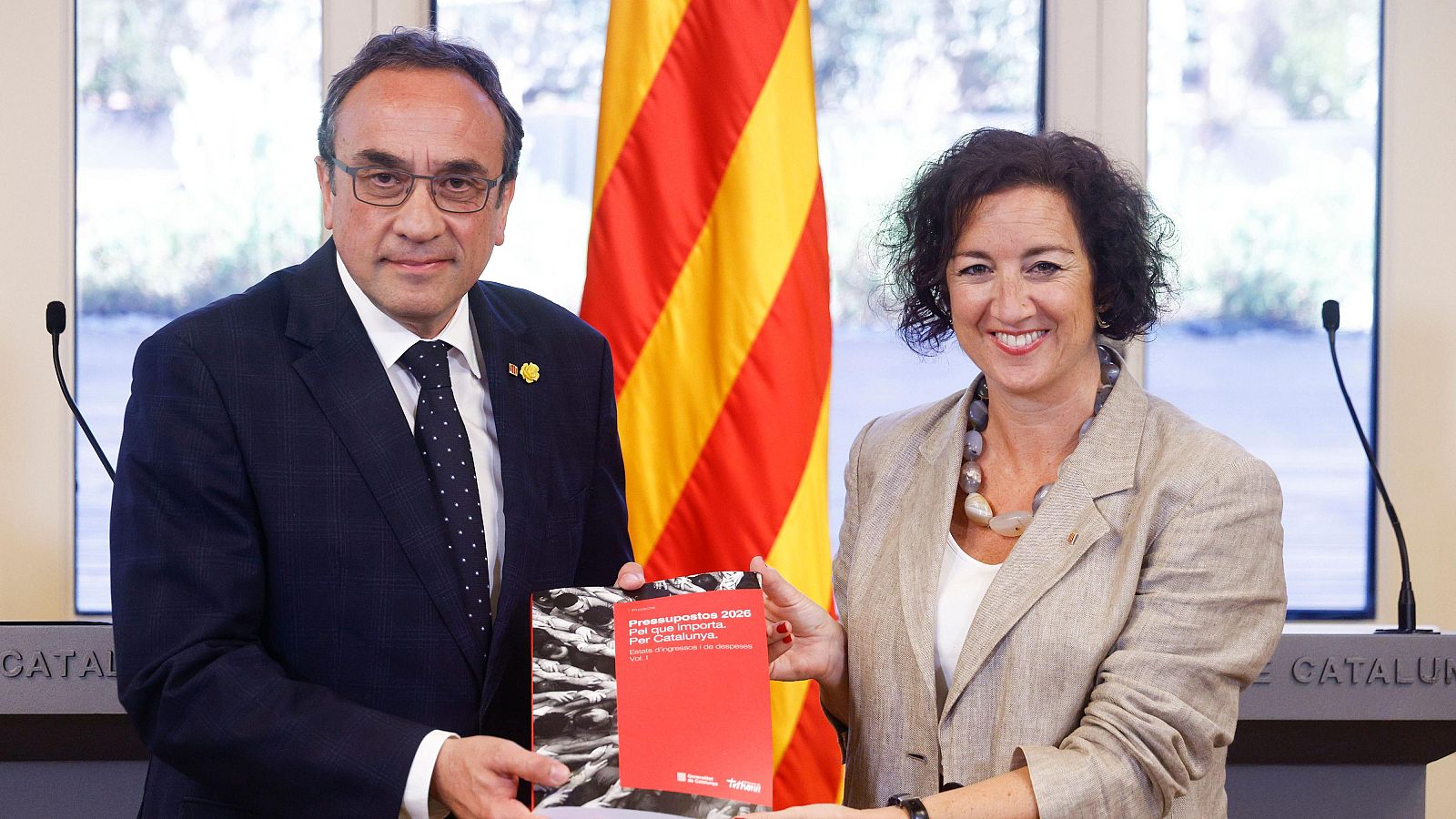 Alícia Rovira i Roger Torrent presenten el projecte de Pressupostos 2026 de Catalunya, amb la Senyera de fons.