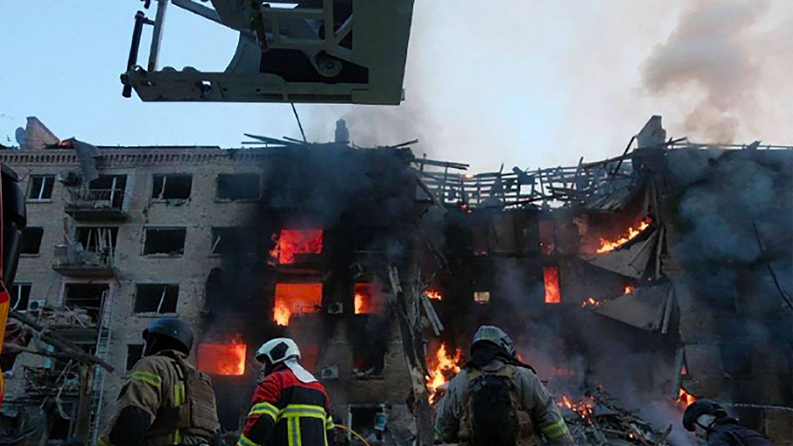Personal de rescate frente a un edificio gravemente dañado tras un ataque ruso contra la capital ucraniana, Kiev, en medio de la invasión rusa de Ucrania.