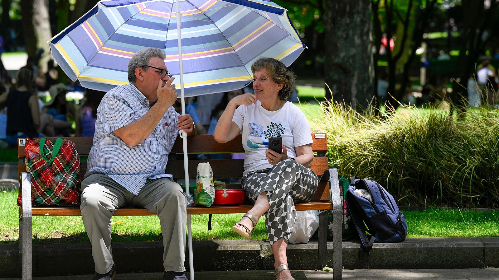 Dos personas se protegen del sol en el centro de Oviedo