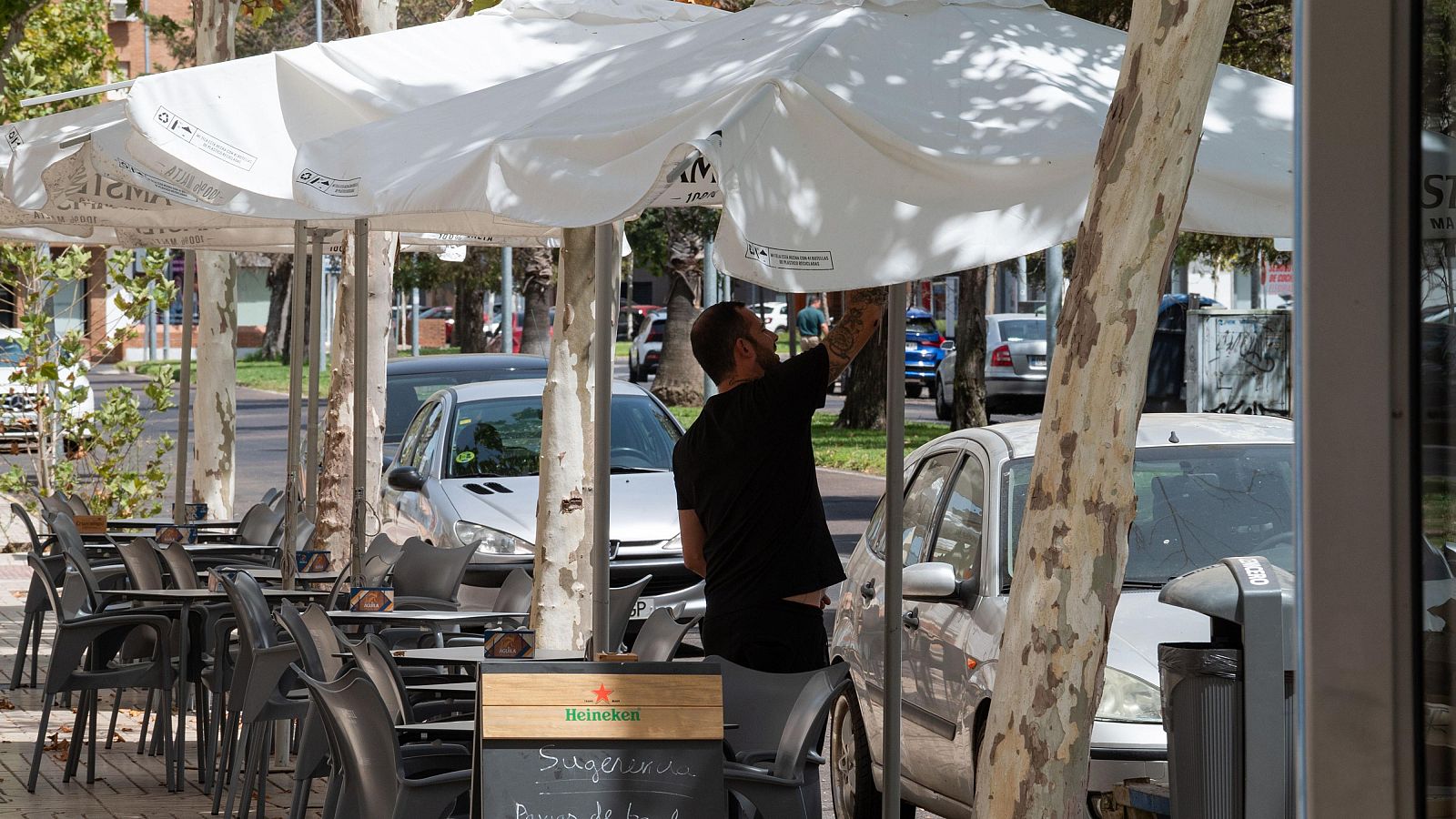 Un hombre organiza la terraza de un bar en Badajoz
