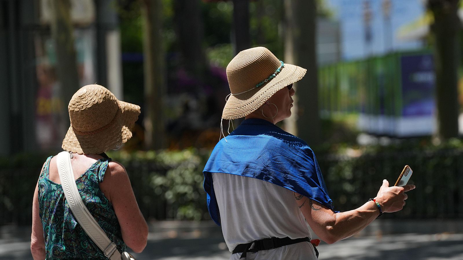 Turistas se protegen del calor durante una visita a Sevilla.