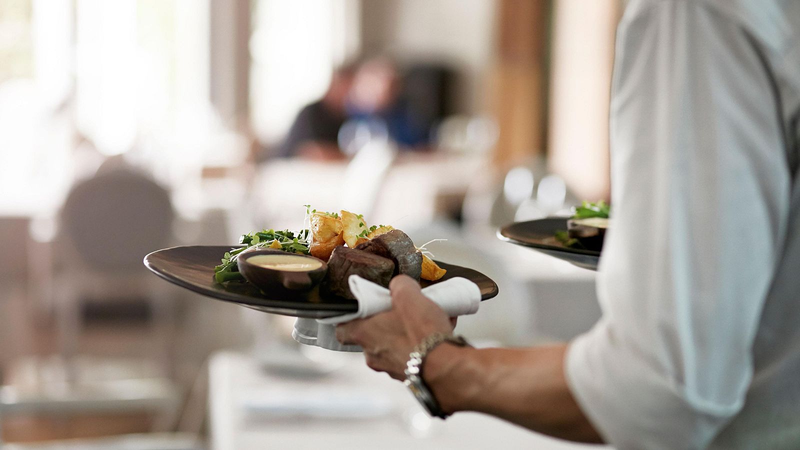 Un camarero sirve la comida en un restaurante