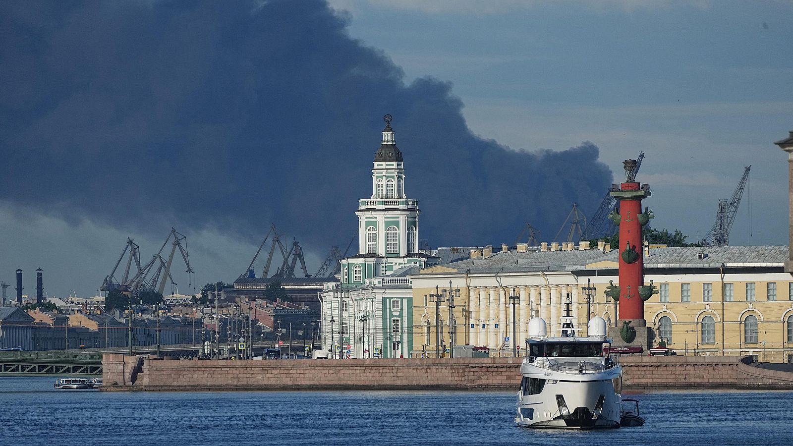 Columna de humo negro sobre el puerto de San Petersburgo, con edificios clásicos y un yate en primer plano. Posible impacto de dron.