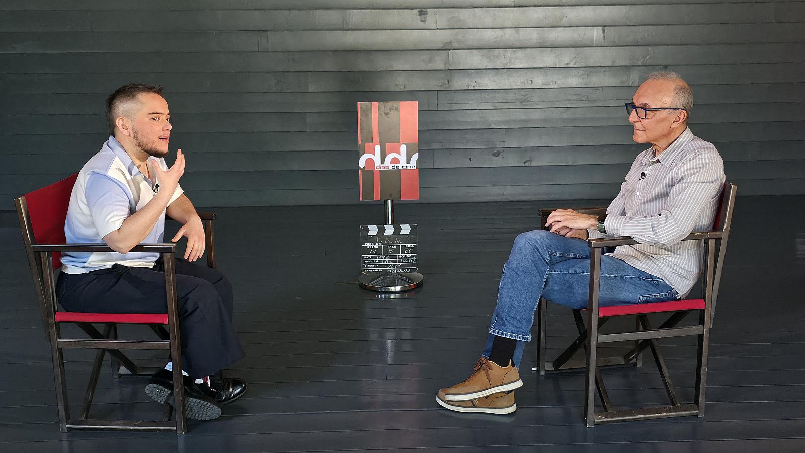 Ian de la Rosa y Gerardo Sánchez en una entrevista, con un cartel de "ddc días de cine" y una claqueta en el centro.