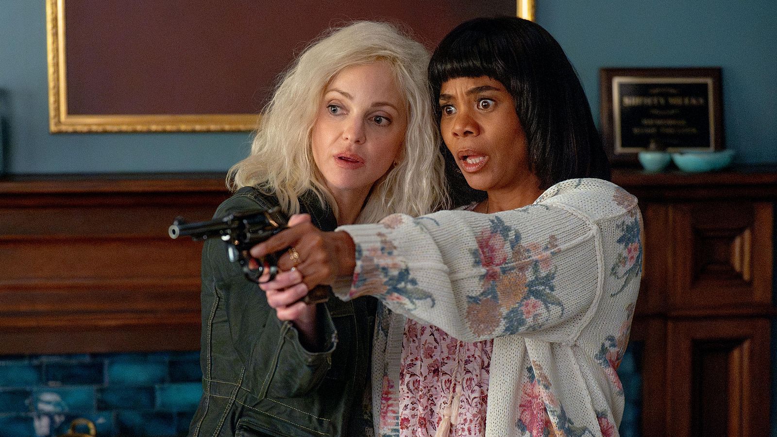 Anna Faris y Regina Hall en una escena de 'Scary Movie'. Faris apunta un arma con seriedad, Hall reacciona con sorpresa.