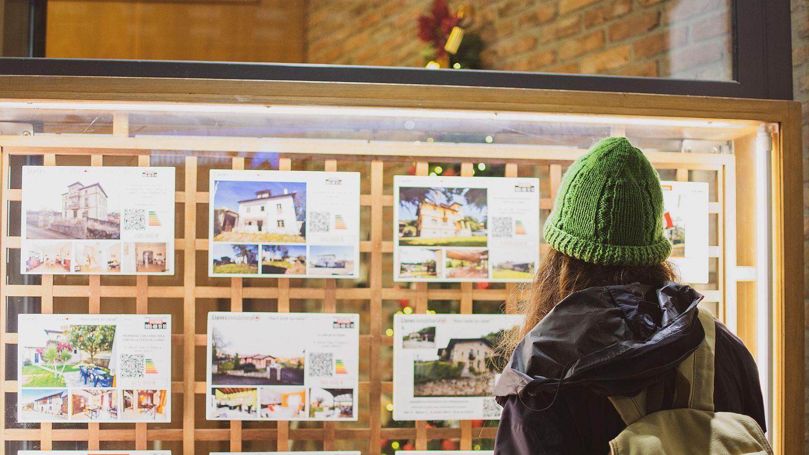 Una mujer delante de una inmobiliaria