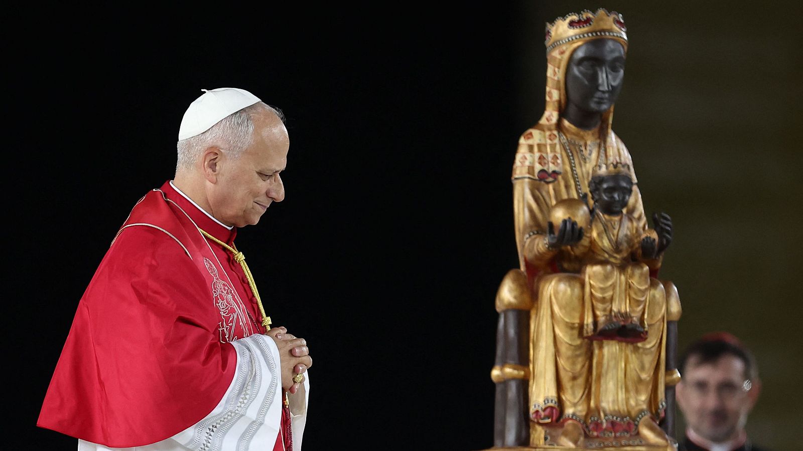 El Papa León XIV reza ante la estatua dorada de la Virgen de Montserrat, representada con piel oscura y coronada, junto al Niño Jesús.