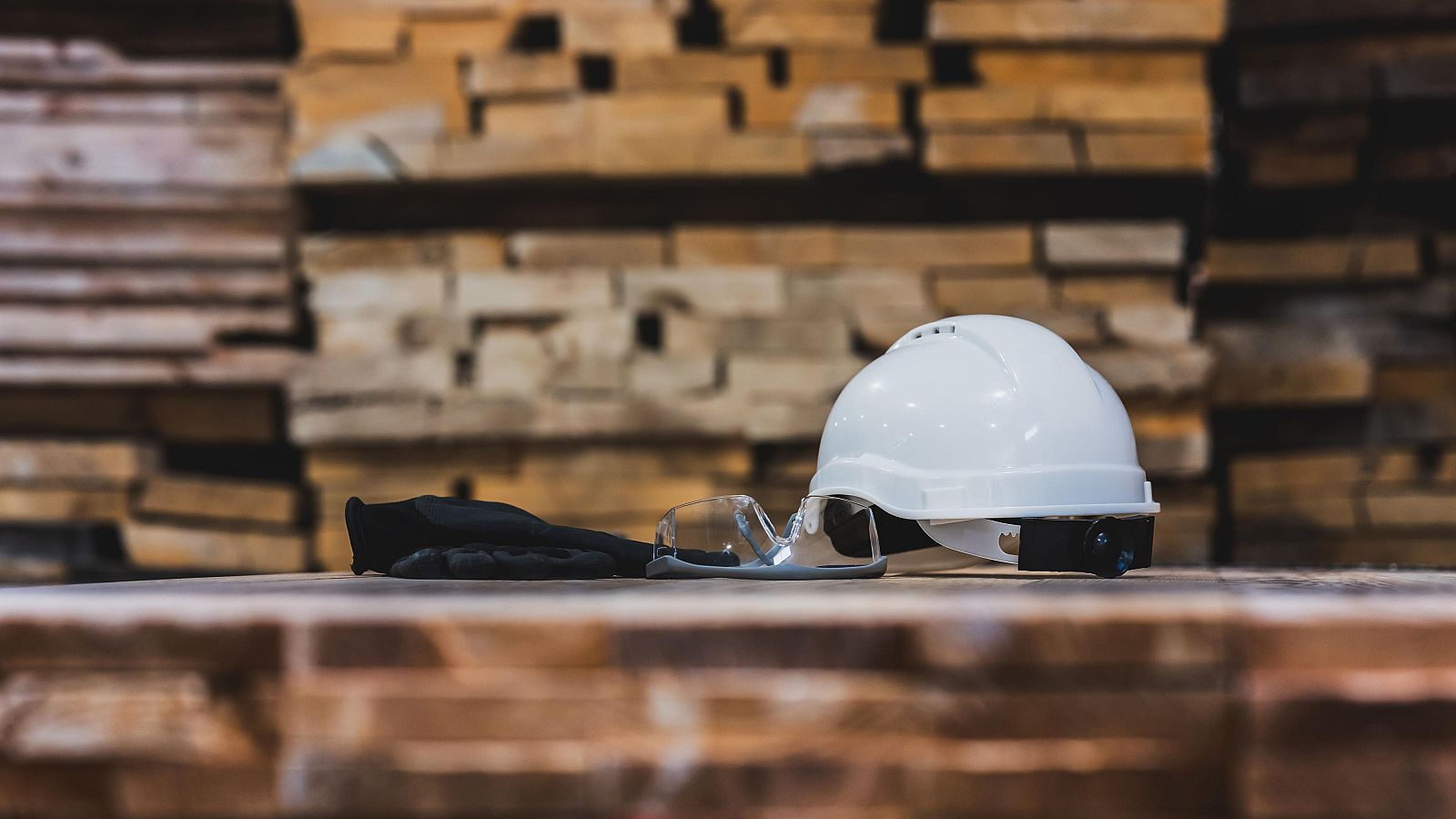 Un casco blanco, gafas de seguridad y guantes de trabajo.