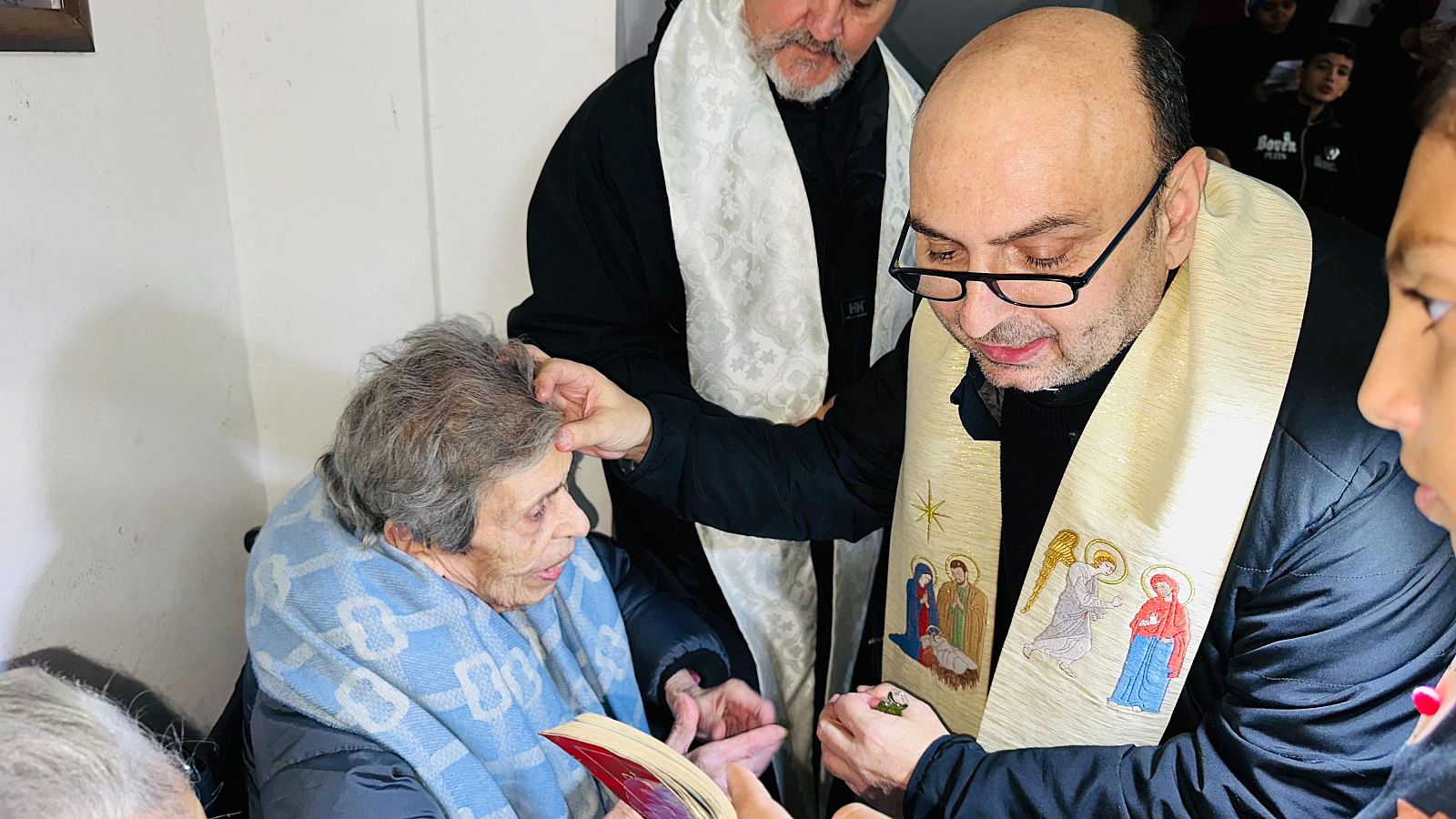 El sacerdote Gabriel Romanelli bendiciendo a una mujer cristiana en la Franja de Gaza
